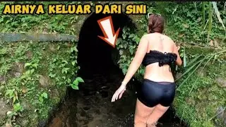 BATHING IN A CLEAR RIVER WITH WATER COMING OUT OF A CAVE
