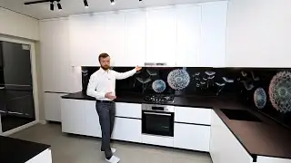 Угловая кухня белого цвета. Столешница керамогранит черный. Кухня под натяжной потолок.