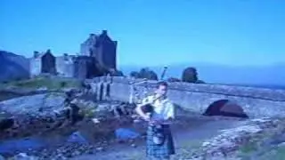 Scotland Highland Music - Bagpiper in front of the Eilean Donan Castle