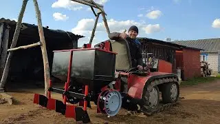 Homemade potato planter for a mini-tractor with caterpillar tracks.