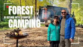 Forest camping in autumn with a camper