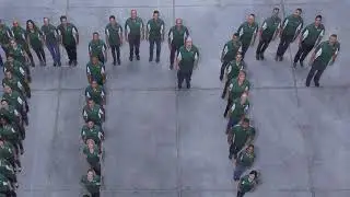 Unusual group photograph of about 60 subjects in the shape of letters
