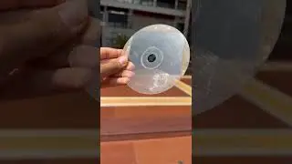 3 D hologram of a cube on a compact disc under diffused reflection of sunlight