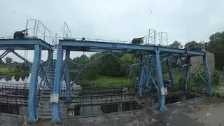Abandoned industrial structure in a lush green landscape