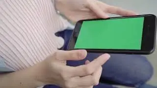 Woman Using Smartphone Device With Green Screen.