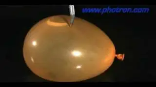 Slow motion video  of a knife bursting a water balloon