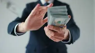 Formally dressed bearded man makes money rain from US stock video