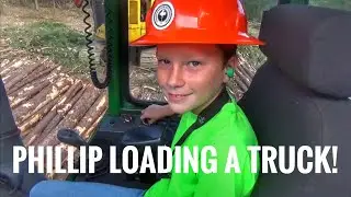 11 year old Phillip loading a log truck with a John Deere 437D