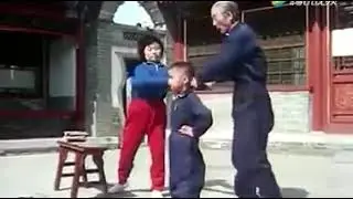 Asian child undergoing martial conditioning: Breaking shingles on the head