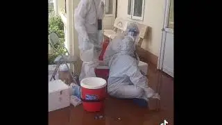 Hình ảnh nhân viên y tế đổ nước đá lên người làm dịu cơ thể trong bộ đồ bảo hộ dưới cái nắng 40 độ