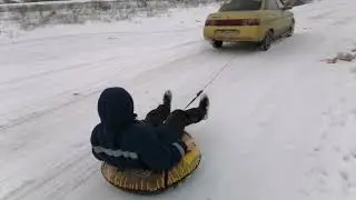 Катаюсь на ватрушке за машиной.