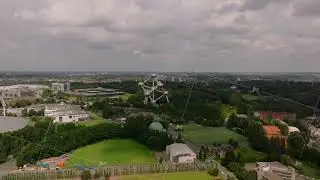 Aerial views highlight the atomium and its lush park in Brussels, Belgium, with drifting clouds