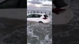 Car smashed by surf at high tide!