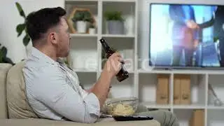 Mid-Aged Man Eating Chips and Drinking Beer while Watching TV at Home | Stock Footage - Envato e...