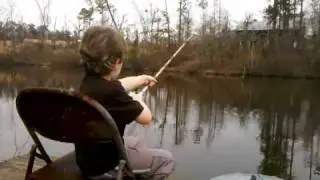 Ethan learning to cast a fishing pole at Pa Paw's.