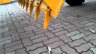 Девушка закрывает коробок ковшом погрузчика