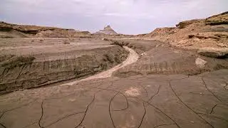 8K Stock Video - Overlooking cracked mud landscape drying out after flash flood at Factory Butte
