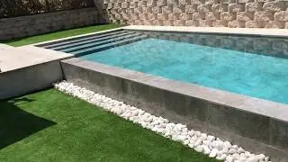 Piscina pequeña, moderna y alargada con desborde tipo infinito.