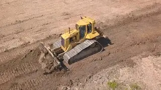 Бульдозер Cat D6N LGP снимает плодородный слой - Drone video