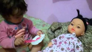 Fabia Melyssa cuidando com amor da sua boneca Flavinha.