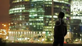 The Young Man And Sky-Scrapers Background At Night, Time Lapse. Stock Footage