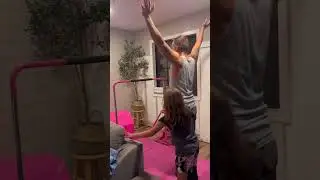 Girls are teaching their daddy gymnastics. 