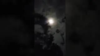 psychedelic clouds dance across a full moon above the big piney river on an October sky
