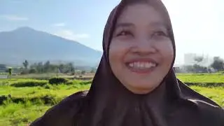 Free horizontal footage | people walking field with mountain and plantation area to the residents