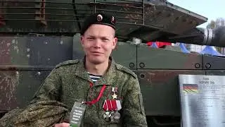 Скромный герой России, перед подбитым немецким «Леопардом» напутствует детей на выставке трофеев.