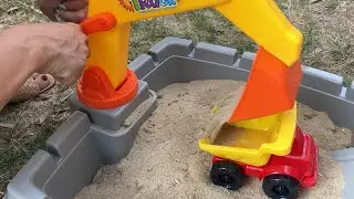 Constructor with excavator with sand and car