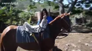 Indian girl taming her lazy wild horse hardly