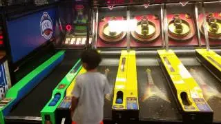 Daniel playing skee-ball at Chuck E Cheese