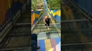Карлик пытается преодолеть стеклянный мост без поручней