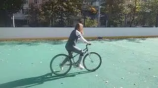Елизавета учится кататься на велосипеде с тренером.