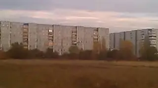 мужык за пускает  модель самолёта на поляне.