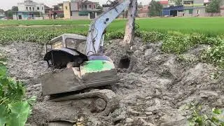 Excavator crash bogged down in deep mud - Excavator driving effort to escape the swamp