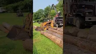 log truck unloading logs for sawmill.