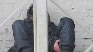 ЖЕНЩИНА БОМЖИХА СИДИТ НА АСФАЛЬТЕ