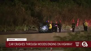 Car crashes through woods ending on highway