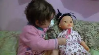 Bebê dando comidinha pra boneca.