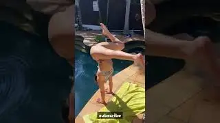 The asian yoga girl make asanas at the pool 