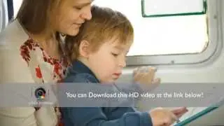 Little child with pad sitting on mothers lap in the train