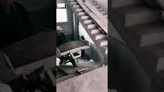 Hardworking construction workers pushing concrete cart up stairs