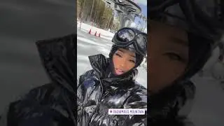 Black shiny down jacket and patent black leggings. Girl in a shiny winter suit, helmet and ski mask.