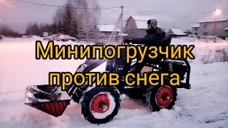 Минипогрузчик чистит снег