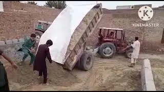 A tractor trolley is unloading soil