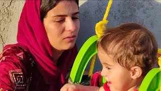 Nomadic village:single mother bathing her two babies in the traditional way