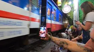 Поезд проезжает через жилой квартал мимо кафе. Ханой, Вьетнам