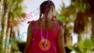 young slim girl is walking on a tropical garden in sunny weather, back view, camera is moving from t