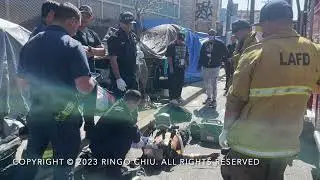 Emergency responders give first aid to a homeless man